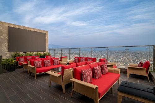 a room with red chairs and a screen on a building at Mercure Kathmandu Sukedhara Heights in Kathmandu