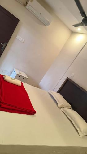a room with a bed with a red blanket on it at Karmaliz Casa Del Lake in Chavara