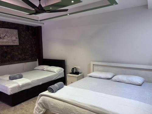 a bedroom with two beds and a ceiling at Karmaliz Casa Del Lake in Chavara