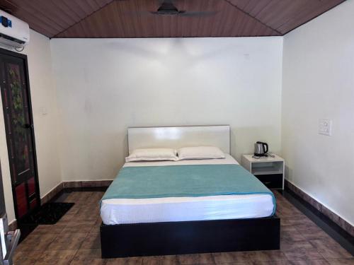 a bedroom with a large bed with a green blanket at Karmaliz Casa Del Lake in Chavara