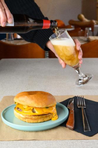 a person holding a glass of beer and a sandwich at UNDUESINA Albergue Undués de Lerda in Undués de Lerda