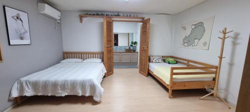 a bedroom with a bed and a mirror at Another day in Jeju in Seogwipo