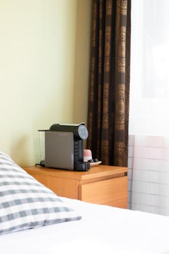 a bedroom with a bed and a monitor on a dresser at Motel-Restaurant 13 Etoiles in Saint-Léonard