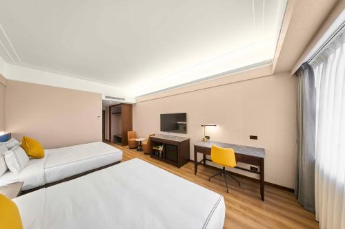 a hotel room with a bed and a desk at Fullon Poshtel Jhongli in Zhongli