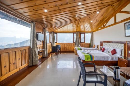 a bedroom with a bed and a table and chairs at Deep Hotel in Mussoorie