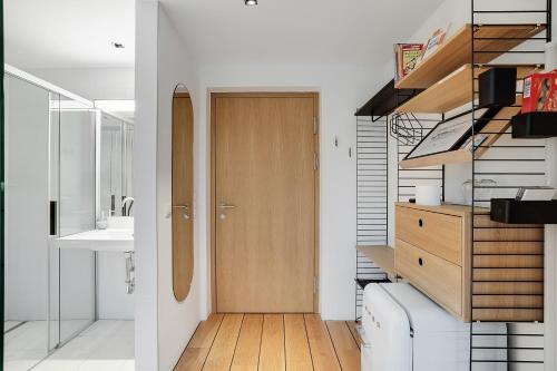 a hallway with a wooden door in a bathroom at Idyllische Seeblick-Apartments - Auszeit am Thaler See Garten Graz in Graz