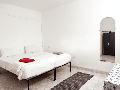 a white bedroom with a bed with a red blanket at Rosa Mystica in Cola