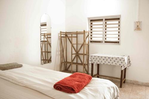 a bedroom with a bed and a table and a window at Rosa Mystica in Cola