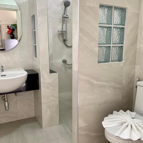 a bathroom with a shower with a sink and a toilet at SUAN SANG CHAN RIVERSIDE Resort สวนแสงจันทร์ ริเวอร์ไซด์ รีสอร์ท in Ban Bang Khoi