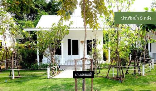 a sign in front of a white house at สวนเพื่อคุณ รีสอร์ทแอนด์แคมป์ปิ้ง in Ban Don Wan