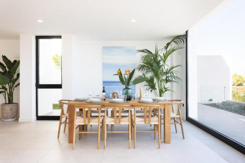a dining room with a wooden table and chairs at Gorvorana 3 - Piscina privada, BBQ in Realejo Bajo