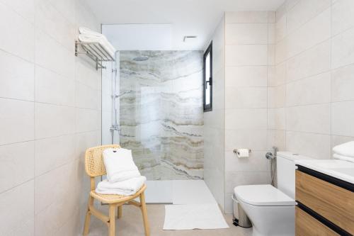 e bagno con doccia, servizi igienici e sedia. di Gorvorana 3 - Piscina privada, BBQ a Realejo Bajo