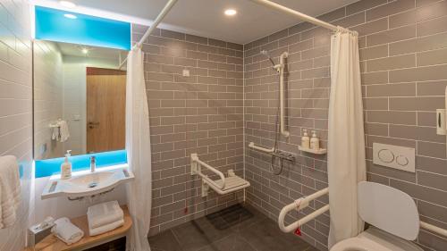 a bathroom with a sink and a shower at Holiday Inn Express - Hamburg South A7-AS42 by IHG in Egestorf