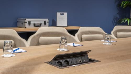 a conference room with a table with chairs and a projector at Holiday Inn Express - Hamburg South A7-AS42 by IHG in Egestorf