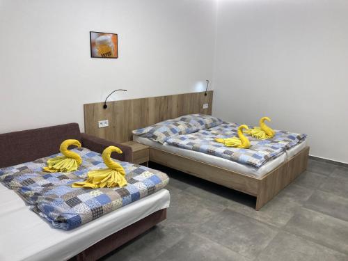 three yellow rubber swans on beds in a room at New Pension at ROTOR Brewery in Kunovice
