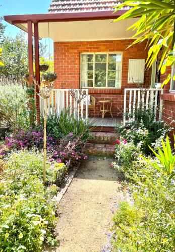 a red brick house with a porch and flowers at Rosehaven on Rosebud in Rosebud