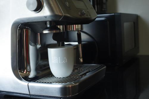 a coffee maker is making a cup of coffee at Lá Riverside Boutique Hotel in Mỹ Phước