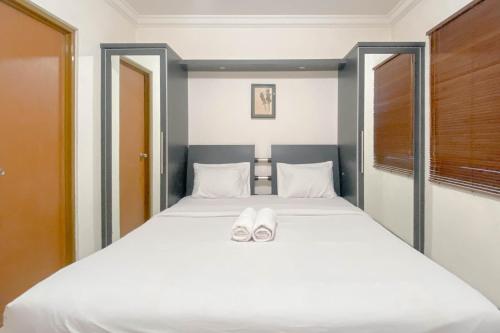 a bedroom with a bed with white shoes on it at Spacious Luxury 2BR at Majesty Apartment By Travelio in Bandung
