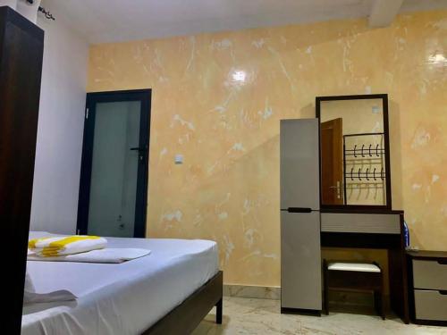 a bedroom with a bed and a dresser and a mirror at Gombe243 in Kinshasa