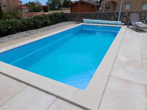 una piscina con acqua blu in un cortile di Villa Lavender's Breeze a Kornić
