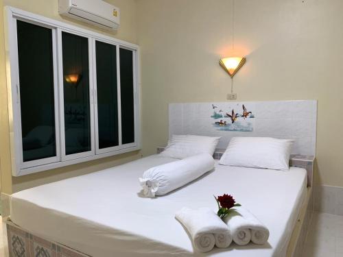 a bedroom with a large white bed with towels on it at SUAN SANG CHAN RIVERSIDE Resort สวนแสงจันทร์ ริเวอร์ไซด์ รีสอร์ท in Ban Bang Khoi