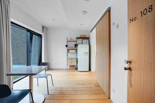 a hallway with a table and a refrigerator in a room at Idyllische Seeblick-Apartments - Auszeit am Thaler See Garten Graz in Graz