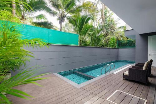 una piscina con una silla junto a una casa en Luxury Villa- Casa VedaAssagao, en Chandīgarh