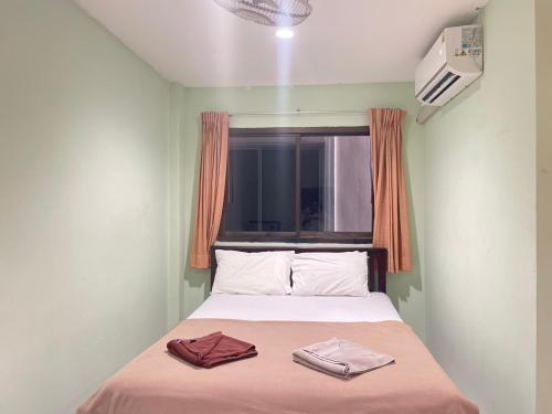 a bed in a room with two towels on it at SHERRY'S Guest House in Patong Beach