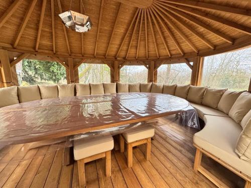 a large wooden table in a pavilion with a couch at Gite De La Borie in Saint-Ignat