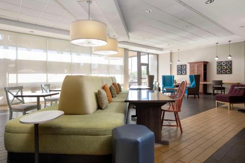 a living room with a couch and tables and chairs at Home2 Suites By Hilton Phoenix-Tempe University Research Park in Tempe