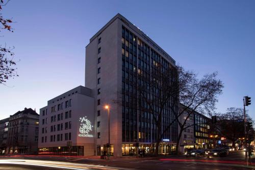 杜塞尔多夫Me and All Hotel Dusseldorf, by Hyatt的夜晚城市街道上的一栋大楼