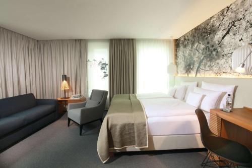 a hotel room with a bed and a couch at Me and All Hotel Dusseldorf, by Hyatt in Düsseldorf