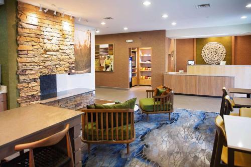 a lobby of a hotel with a stone wall at AmericInn by Wyndham Hays in Hays