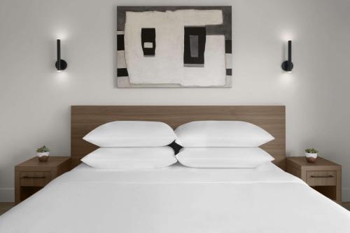 a bedroom with a white bed with two pillows at The Lum Hotel Los Angeles Stadium District in Inglewood