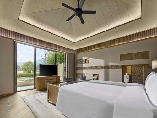 a bedroom with a large bed with a ceiling fan at Hilton Suzhou New District in Suzhou