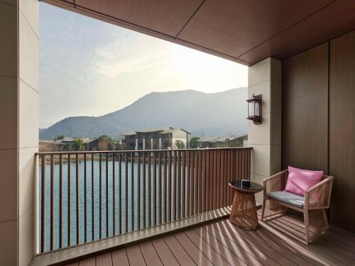 a balcony with a chair and a view of a mountain at Hilton Suzhou New District in Suzhou