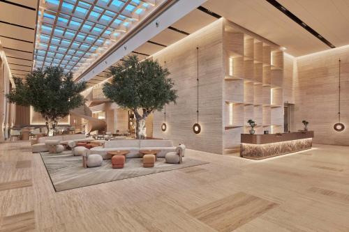 a lobby with couches and a tree in the middle at Hilton Gurugram Baani City Centre in Gurgaon
