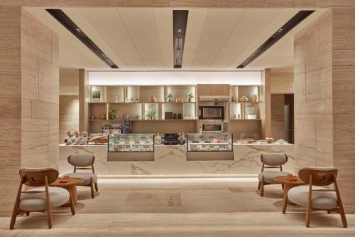 a rendering of a kitchen with chairs and tables at Hilton Gurugram Baani City Centre in Gurgaon