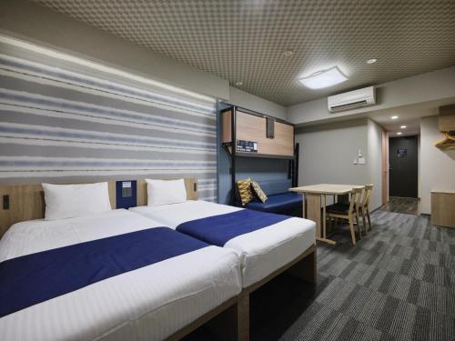 a bedroom with a large bed and a table at MONday Apart Premium AKIHABARA ASAKUSABASHI Sta. in Tokyo