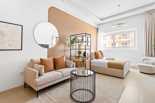a living room with a couch and a bed at Silkhaus Vacation Homes New Studio in ASB Tower Walking distance to mall in Dubai