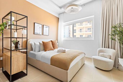a bedroom with a bed and a chair and a window at Silkhaus Vacation Homes New Studio in ASB Tower Walking distance to mall in Dubai