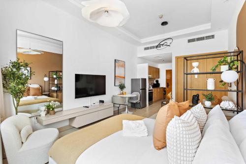 a living room with a white couch and a tv at Silkhaus Vacation Homes New Studio in ASB Tower Walking distance to mall in Dubai