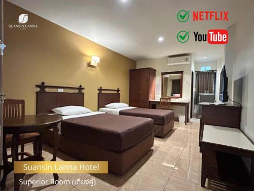 a hotel room with two beds and a table at Suansin Lanna Hotel in Tak