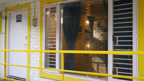 a yellow railing in front of a house with a window at Julley Commune Rishikesh in Rishīkesh