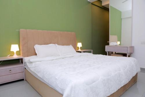 a bedroom with a large white bed with two lamps at Galaxy Getaway in Rajagiriya in Rajagiriya
