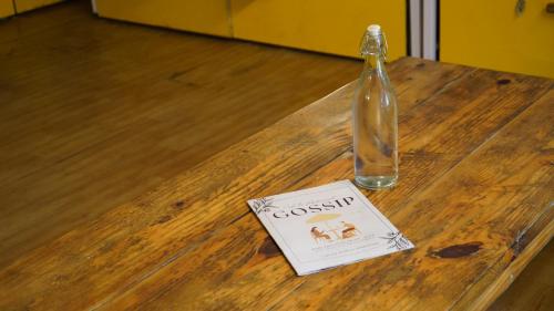 a book and a bottle on a wooden table at Julley Commune Rishikesh in Rishīkesh