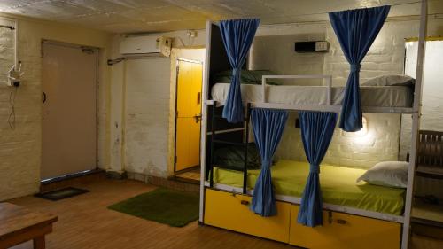 a room with two bunk beds and a door at Julley Commune Rishikesh in Rishīkesh