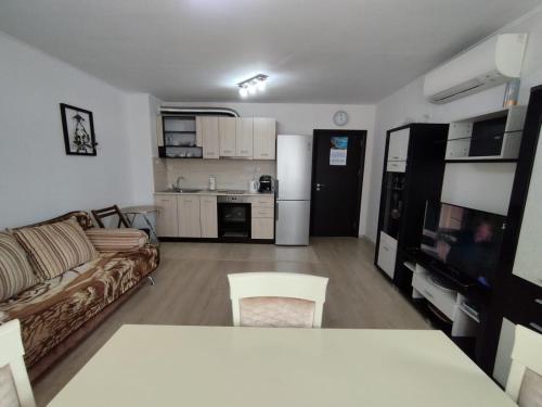 a living room with a couch and a kitchen at Апартамент Сандански Център in Sandanski