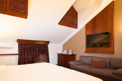 a hotel room with a bed and a couch at Le Cedrus Hotel in Al Arz