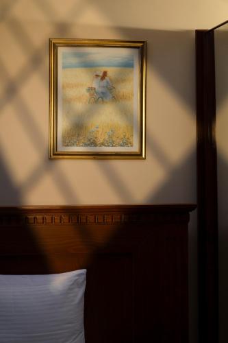 a picture on the wall above a bed in a bedroom at Le Cedrus Hotel in Al Arz